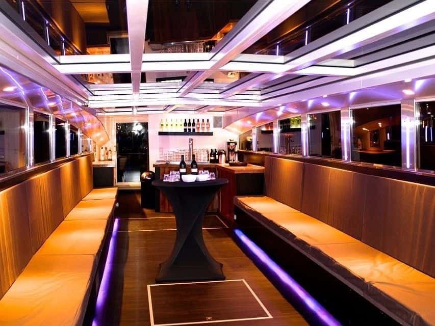 Luxe partycharter op een boot met sfeervolle verlichting en comfortabele zitplaatsen.