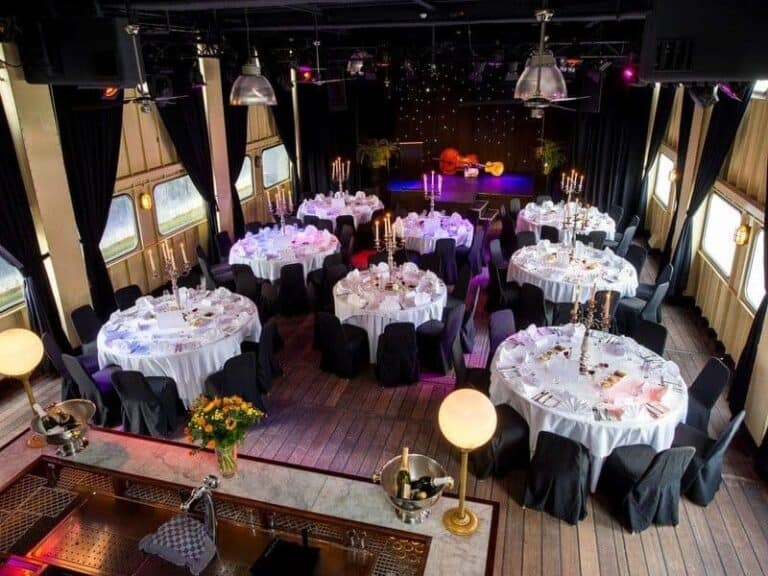 Luxe feestcharter op een boot met elegante tafelopstellingen en sfeervolle verlichting.