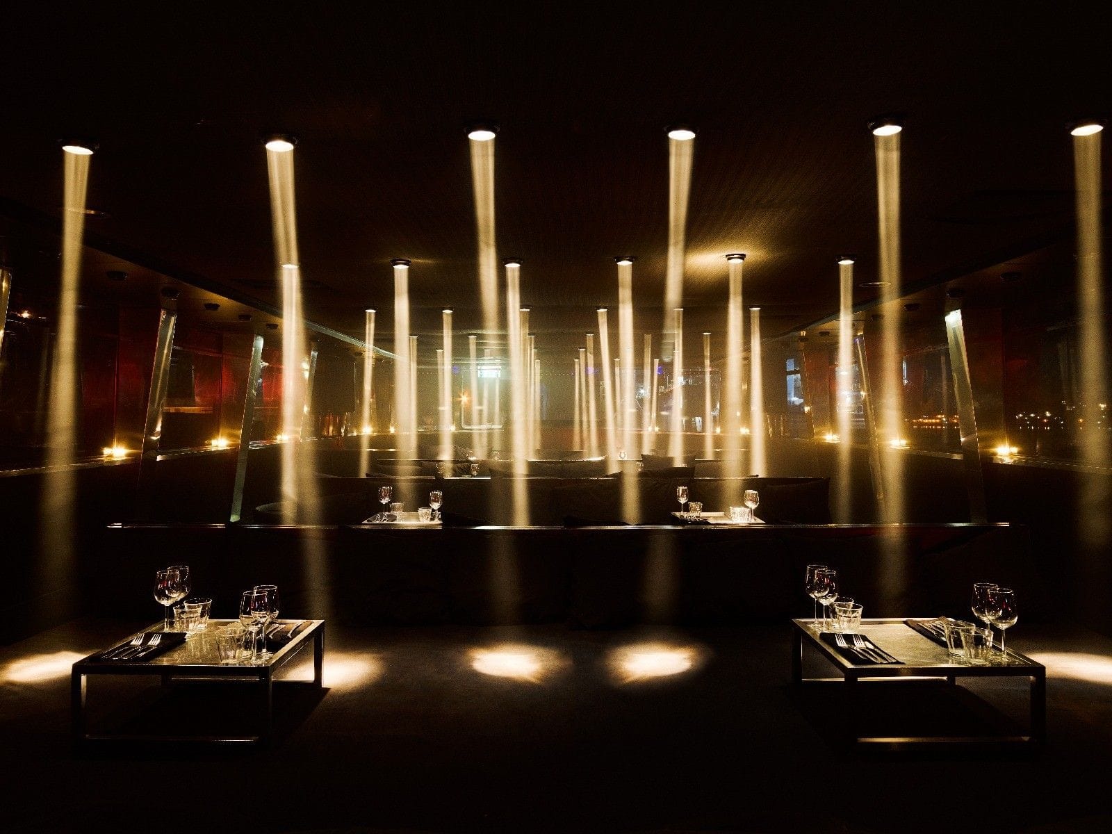 Luxe partyboot met verlichte dansvloer en zithoeken voor feest en ontspanning.